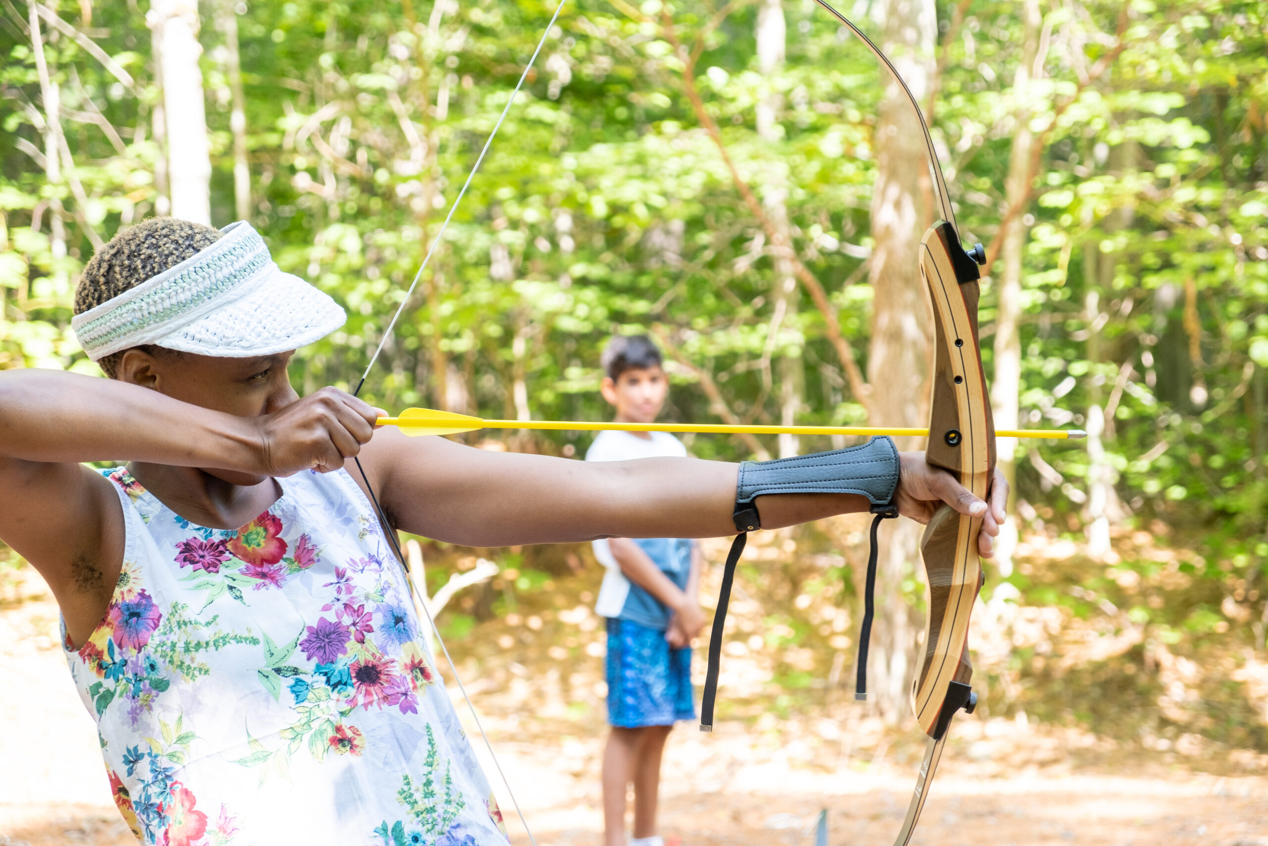 A child at Camp Hale shooting a bow and arrow