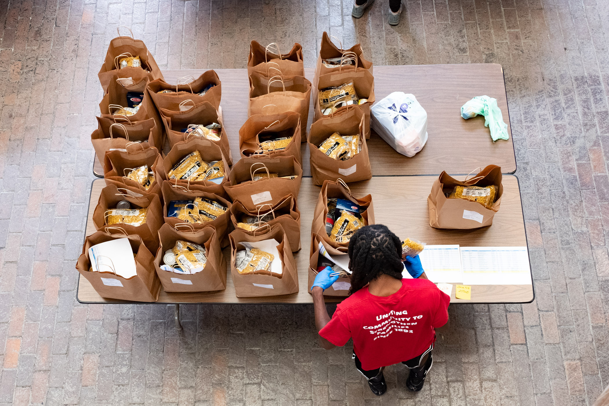 A USES employee is sorting bags of groceries for families