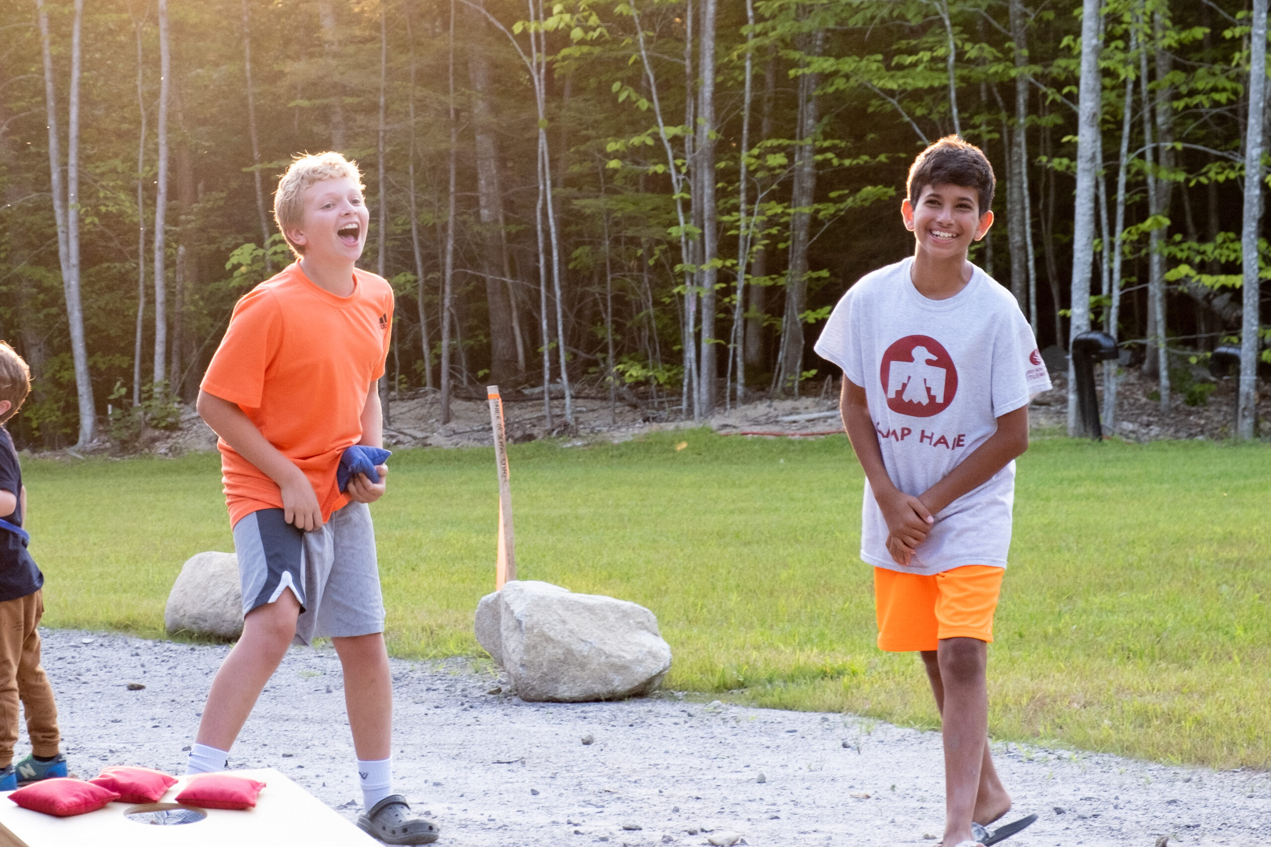 Two young boys are playing and laughing outside at Camp Hale